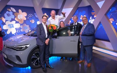 Der glückliche Gewinner des Hauptpreises - ein VW ID.4 - zusammen mit den beiden Geschäftsführern von LOTTO Niedersachsen, Axel Holthaus und Sven Osthoff und Moderator Michael Thürnau